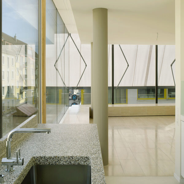 Eck-Wohnung mit Küchenzeile vor der gläsernen Fassade